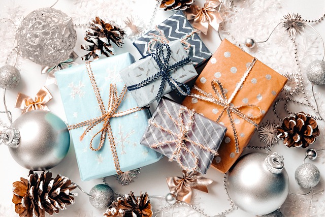 Picture of gifts with holiday wrapping paper, ornaments and pine cones.